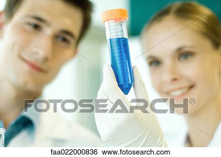 Young male and female scientists, woman holding up test tube View Large Photo Image Stock Photograph - Young male and female scientists, woman holding up test tube. Fotosearch