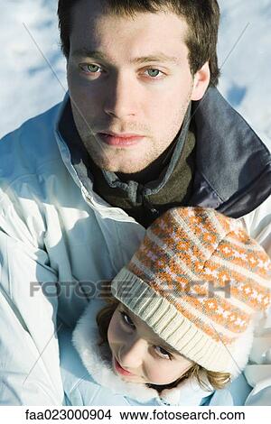 Picture - Young man embracing younger sister, both looking at camera, portrait, high angle view. Fotosearch