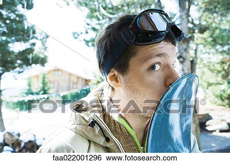 Young man kissing snowboard, glancing at camera View Large Photo Image Stock Photograph - Young man kissing snowboard, glancing at camera. Fotosearch