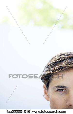 Young man looking at camera, cropped view of head View Large Photo Image Stock Photograph - Young man looking at camera, cropped view of head. Fotosearch