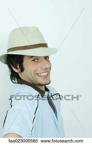 Young man looking over shoulder at camera, smiling, portrait View Large Photo Image Stock Photography - Young man looking over shoulder at camera, smiling, portrait. Fotosearch