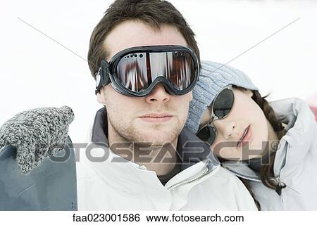 Young man standing with snowboard, little sister resting head on his shoulder View Large Photo Image Stock Photograph - Young man standing with snowboard, little sister resting head on his shoulder. Fotosearch