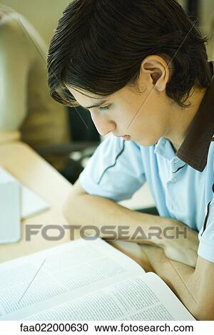 Young man studying in university library View Large Photo Image Stock Image - Young man studying in university library. Fotosearch