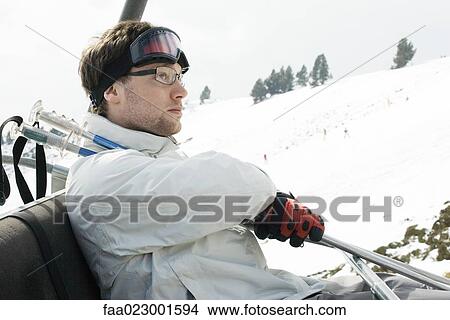 Young man taking ski lift View Large Photo Image Picture - Young man taking ski lift. Fotosearch