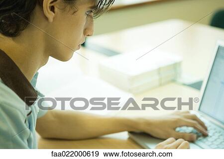 Young man using laptop View Large Photo Image Stock Photo - Young man using laptop. Fotosearch