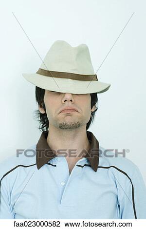 Young man wearing hat, eyes covered, portrait View Large Photo Image Stock Image - Young man wearing hat, eyes covered, portrait. Fotosearch