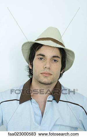 Young man wearing hat, looking at camera, portrait View Large Photo Image Stock Image - Young man wearing hat, looking at camera, portrait. Fotosearch