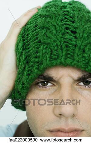 Young man wearing knit hat, looking at camera, furrowing brow View Large Photo Image Stock Image - Young man wearing knit hat, looking at camera, furrowing brow. Fotosearch