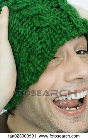 Young man wearing knit hat, one eye covered, laughing at camera View Large Photo Image Stock Image - Young man wearing knit hat, one eye covered, laughing at camera. Fotosearch