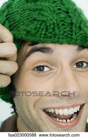 Young man wearing knit hat, smiling at camera, portrait View Large Photo Image Stock Photo - Young man wearing knit hat, smiling at camera, portrait. Fotosearch
