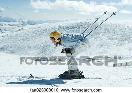 Young skier bending over, side view, full length portrait View Large Photo Image Stock Image - Young skier bending over, side view, full length portrait. Fotosearch