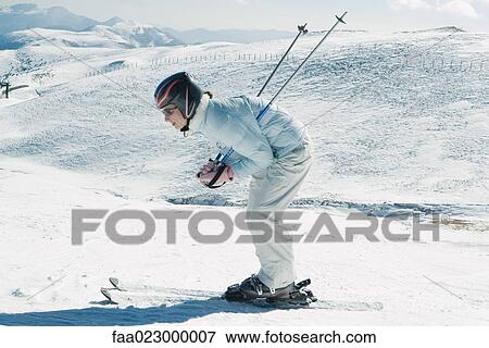 Young skier bending over, side view, full length portrait View Large Photo Image Stock Photo - Young skier bending over, side view, full length portrait. Fotosearch