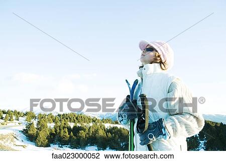 Young skier standing, looking up, side view View Large Photo Image Stock Image - Young skier standing, looking up, side view. Fotosearch