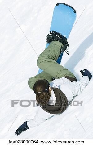 Young snowboarder falling down ski slope, rear view View Large Photo Image Picture - Young snowboarder falling down ski slope, rear view. Fotosearch