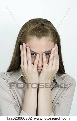 Young woman covering face, peeking at camera, portrait View Large Photo Image Stock Image - Young woman covering face, peeking at camera, portrait. Fotosearch