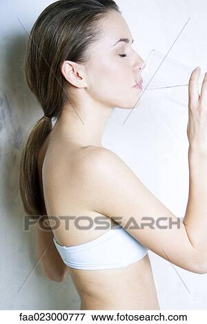 Young woman drinking water, eyes closed, side view View Large Photo Image Stock Photo - Young woman drinking water, eyes closed, side view. Fotosearch