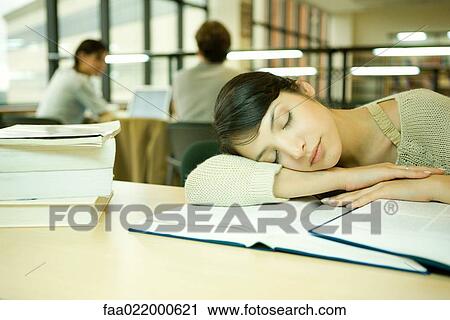 Young woman in university library, head on arm, asleep View Large Photo Image Stock Image - Young woman in university library, head on arm, asleep. Fotosearch