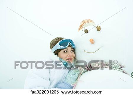 Young woman leaning against snowman, cheek to cheek, portrait View Large Photo Image Stock Photography - Young woman leaning against snowman, cheek to cheek, portrait. Fotosearch