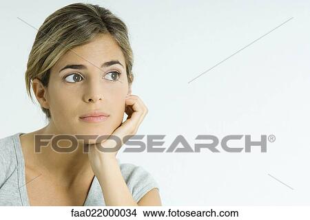 Young woman leaning head on hand, looking away, portrait View Large Photo Image Picture - Young woman leaning head on hand, looking away, portrait. Fotosearch
