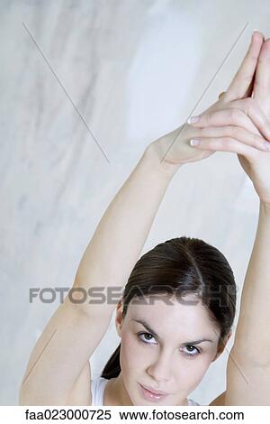 Young woman looking at camera, arms raised, high angle view View Large Photo Image Stock Photography - Young woman looking at camera, arms raised, high angle view. Fotosearch