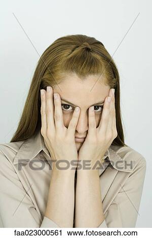 Young woman looking at camera, hands over face, portrait View Large Photo Image Stock Image - Young woman looking at camera, hands over face, portrait. Fotosearch