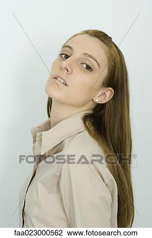 Young woman looking at camera, head back, portrait View Large Photo Image Stock Image - Young woman looking at camera, head back, portrait. Fotosearch