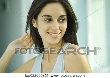 Young woman, looking away, hand in hair, head and shoulders, portrait View Large Photo Image Stock Image - Young woman, looking away, hand in hair, head and shoulders, portrait. Fotosearch