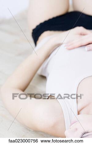Young woman lying on back, wearing underwear, cropped view View Large Photo Image Stock Photograph - Young woman lying on back, wearing underwear, cropped view. Fotosearch