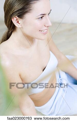 Young woman sitting on the ground, dressed in tubetop, smiling View Large Photo Image Stock Image - Young woman sitting on the ground, dressed in tubetop, smiling. Fotosearch