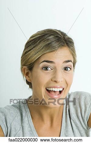 Young woman smiling and raising eyebrows, portrait View Large Photo Image Stock Image - Young woman smiling and raising eyebrows, portrait. Fotosearch