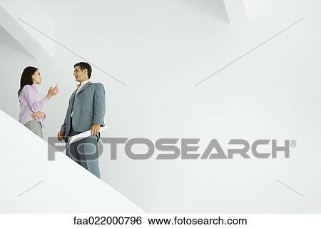 Young woman standing speaking with architect, low angle view View Large Photo Image Stock Photograph - Young woman standing speaking with architect, low angle view. Fotosearch