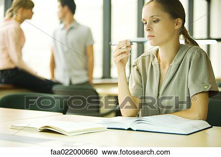 Young woman studying in university library View Large Photo Image Stock Image - Young woman studying in university library. Fotosearch