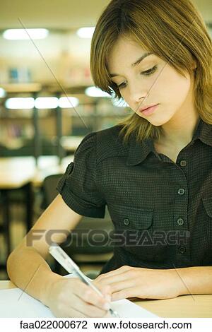 Young woman studying in university library View Large Photo Image Stock Image - Young woman studying in university library. Fotosearch