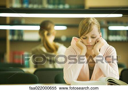 Young woman studying in university library View Large Photo Image Stock Photography - Young woman studying in university library. Fotosearch
