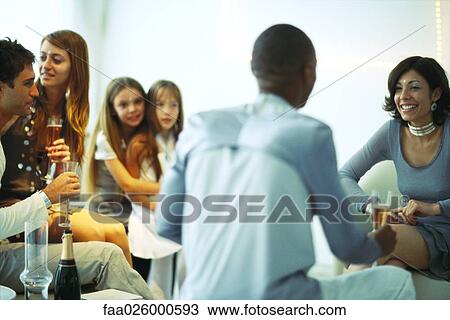 Adult friends drinking champagne at party, little girls embracing in background View Large Photo Image Stock Image - Adult friends drinking champagne at party, little girls embracing in background. Fotosearch