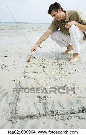Barefoot man writing word "free" on beach with stick View Large Photo Image Picture - Barefoot man writing word "free" on beach with stick. Fotosearch