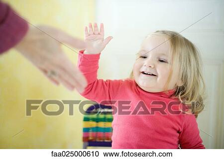 Blonde toddler girl giving adult high five View Large Photo Image Stock Image - Blonde toddler girl giving adult high five. Fotosearch