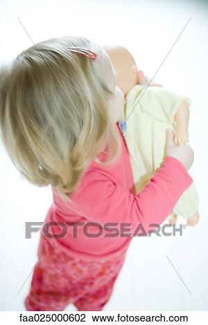 Blonde toddler girl holding baby doll View Large Photo Image Stock Image - Blonde toddler girl holding baby doll. Fotosearch