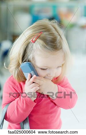 Blonde toddler girl holding cell phone to ear View Large Photo Image Picture - Blonde toddler girl holding cell phone to ear. Fotosearch