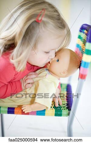 Blonde toddler girl kissing baby doll View Large Photo Image Picture - Blonde toddler girl kissing baby doll. Fotosearch