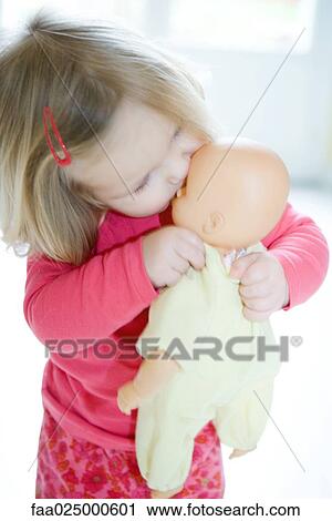 Blonde toddler girl kissing baby doll View Large Photo Image Stock Image - Blonde toddler girl kissing baby doll. Fotosearch
