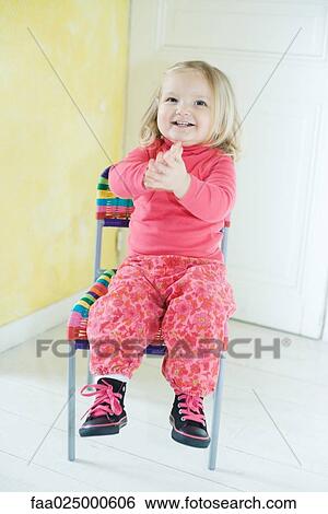 Blonde toddler girl sitting in chair, clapping View Large Photo Image Stock Photograph - Blonde toddler girl sitting in chair, clapping. Fotosearch