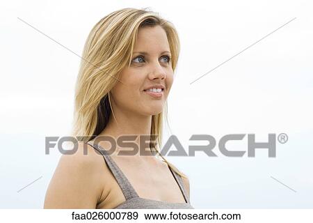 Blonde woman smiling, looking away, head and shoulders View Large Photo Image Stock Photo - Blonde woman smiling, looking away, head and shoulders. Fotosearch