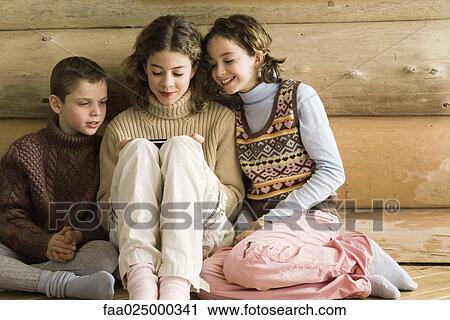 Boy and girl watching teen girl play video game View Large Photo Image Stock Image - Boy and girl watching teen girl play video game. Fotosearch