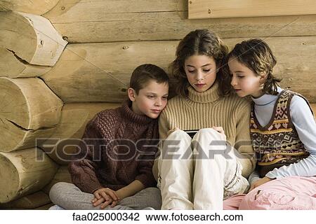 Boy and girl watching teen girl play video game View Large Photo Image Stock Image - Boy and girl watching teen girl play video game. Fotosearch