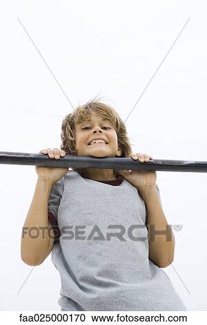 Boy doing pull-up, chin resting on bar, smiling at camera View Large Photo Image Stock Image - Boy doing pull-up, chin resting on bar, smiling at camera. Fotosearch