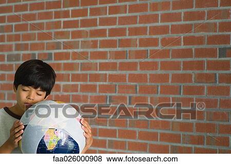 Boy holding globe wrapped in bandages against cheek, eyes closed View Large Photo Image Stock Photo - Boy holding globe wrapped in bandages against cheek, eyes closed. Fotosearch