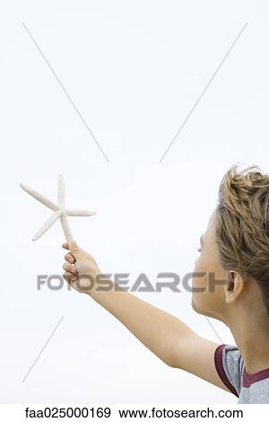 Boy holding up starfish, cropped side view View Large Photo Image Stock Photo - Boy holding up starfish, cropped side view. Fotosearch