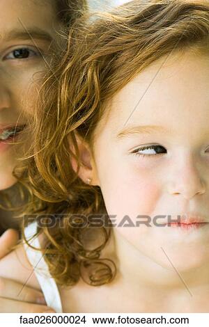 Boy looking over sister's shoulder at camera, both smiling, cropped view View Large Photo Image Picture - Boy looking over sister's shoulder at camera, both smiling, cropped view. Fotosearch