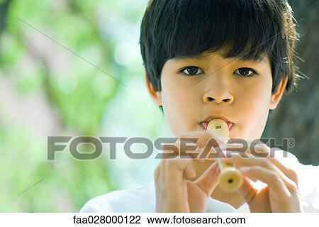 Boy playing flute outdoors, looking at camera View Large Photo Image Stock Image - Boy playing flute outdoors, looking at camera. Fotosearch